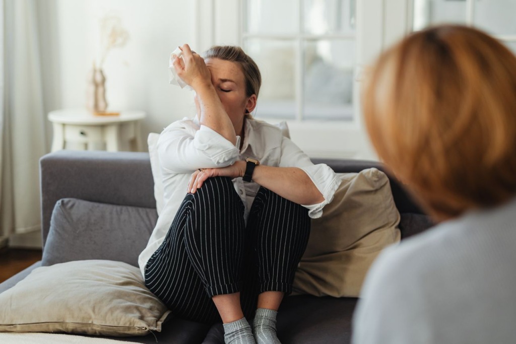A crying woman in a therapy session.